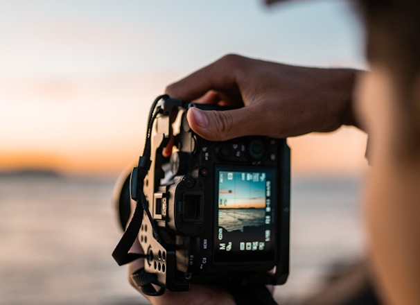 person holding black dslr camera