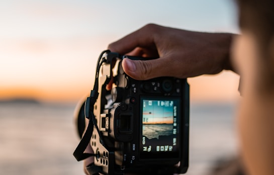 person holding black dslr camera