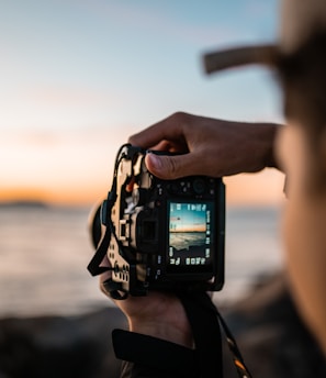 person holding black dslr camera