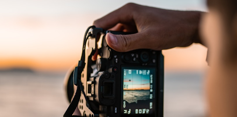 person holding black dslr camera