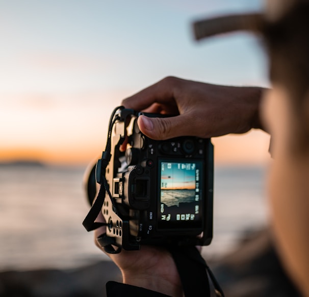 person holding black dslr camera