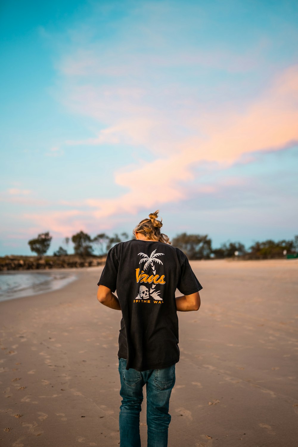 homme en noir ras du cou T-shirt debout sur le sable brun pendant la journée