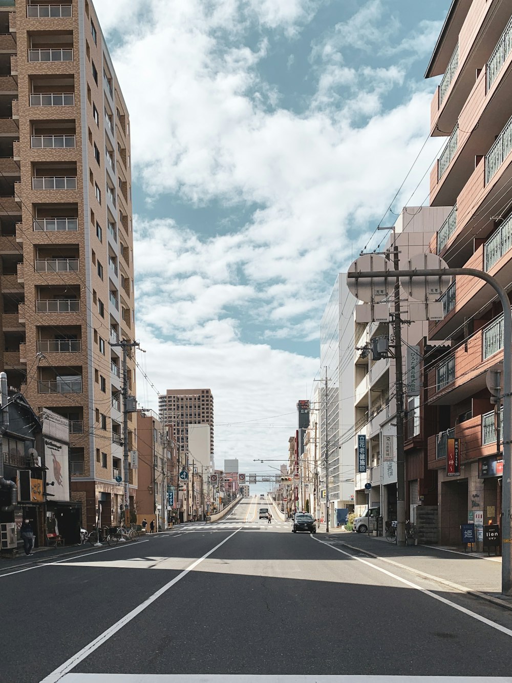 cars parked on side of the road near buildings during daytime