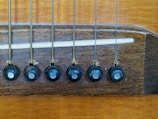 Set of six classical guitar strings stretched over the bridge and fretboard.