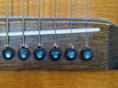 Set of six classical guitar strings stretched over the bridge and fretboard.