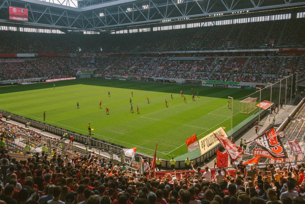 people watching football game during daytime