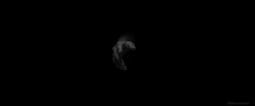 A somber, minimalistic photo showing a hand reaching out through darkness, symbolizing connection and awareness.