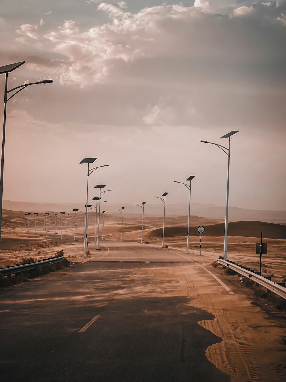 gray concrete road under cloudy sky during daytime