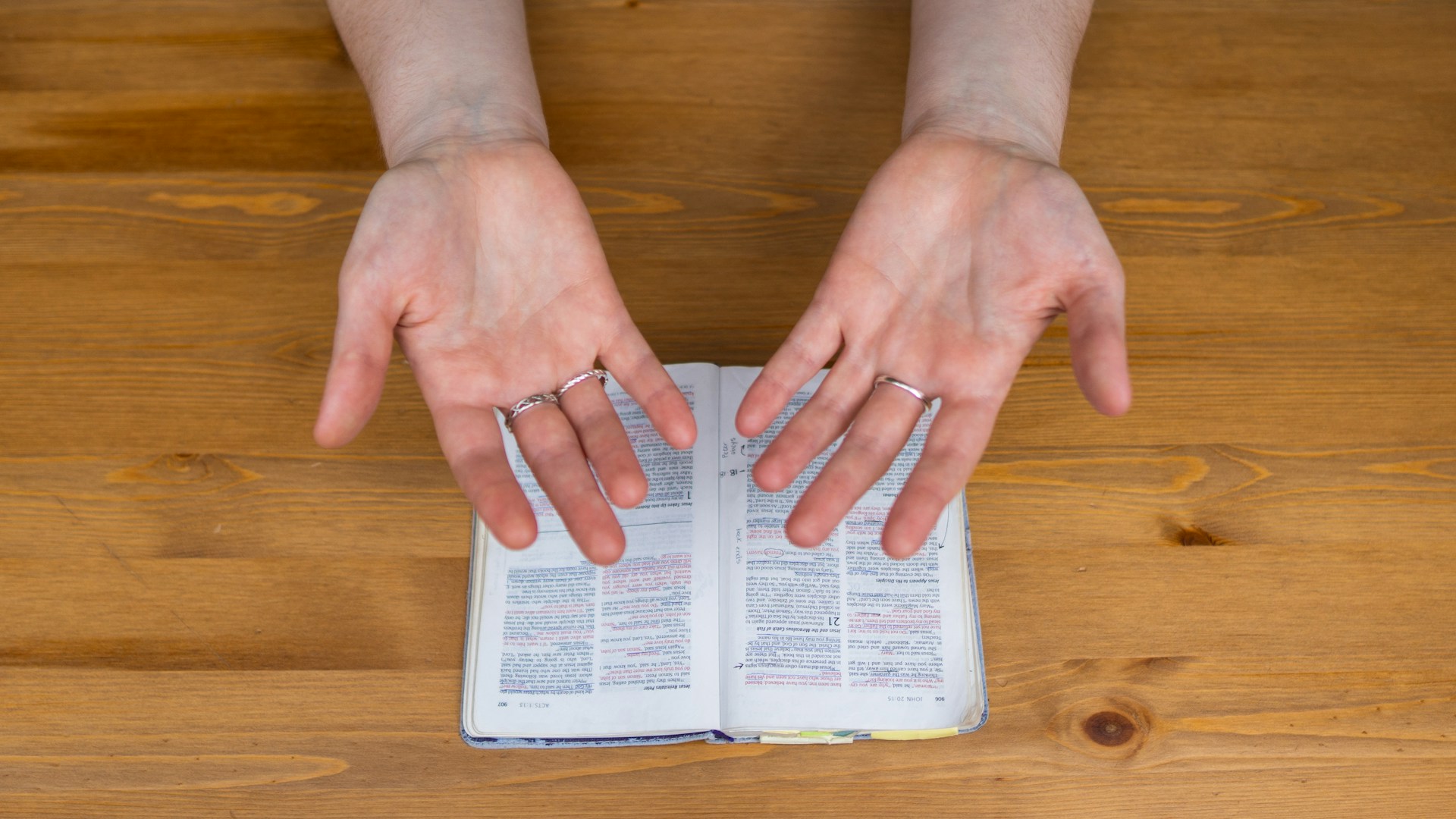 person wearing silver ring holding white box