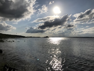 A scenic view of a lake reflecting the sky, captured during a midday walk.