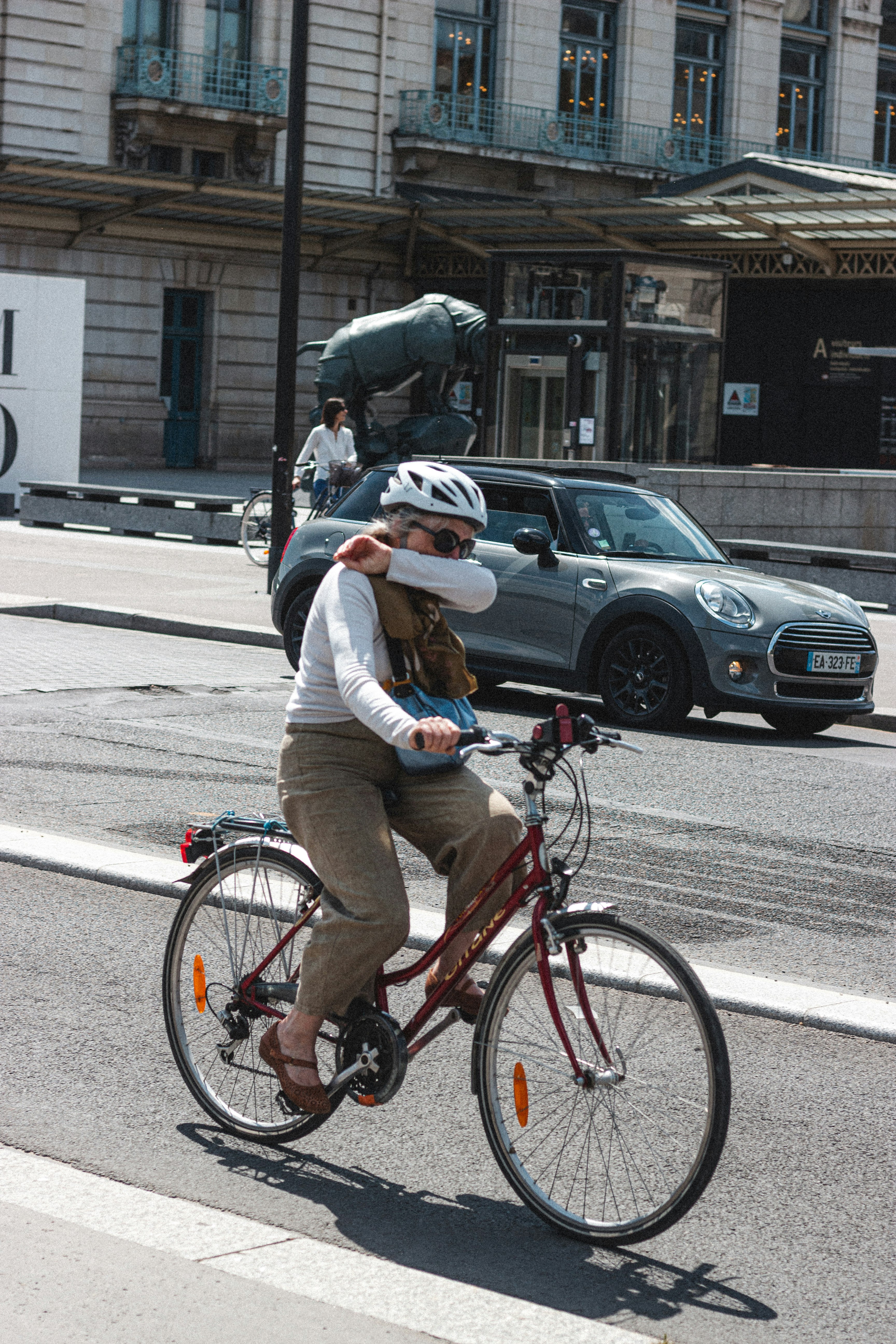 man in brown jacket riding bicycle on road during daytime