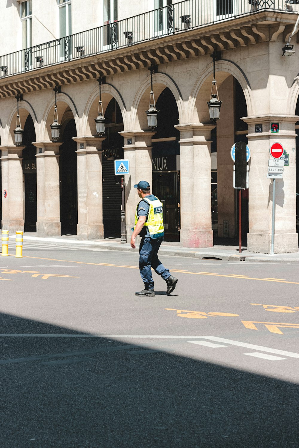 man in blue jacket and black pants walking on gray asphalt road during daytime