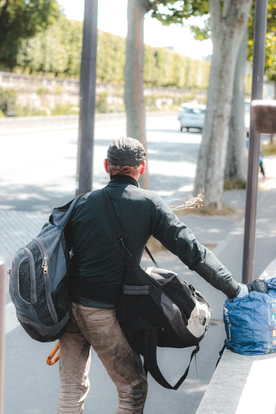 man in black jacket and blue denim jeans riding on black and white motorcycle during daytime