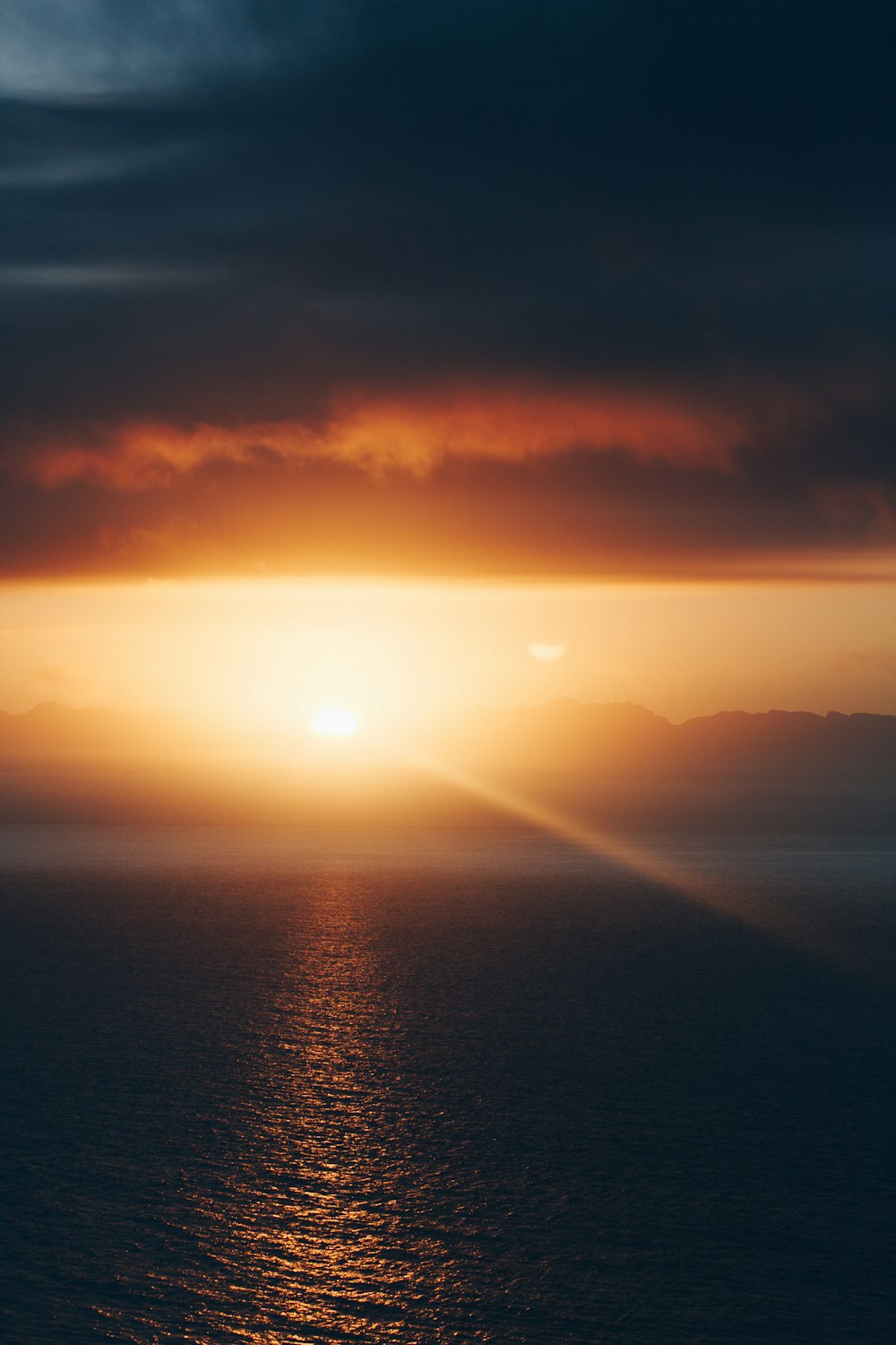 body of water under cloudy sky during sunset