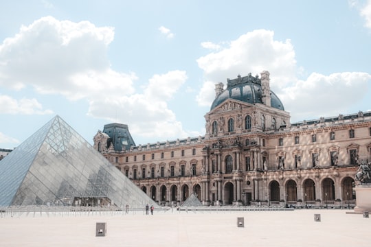 brown concrete building under blue sky during daytime in Louvre France