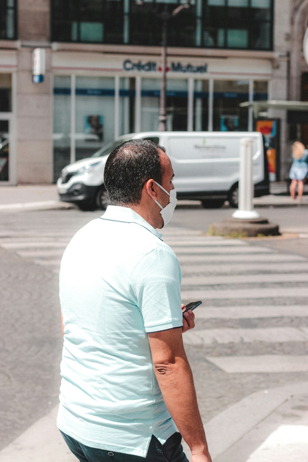 man in white crew neck t-shirt sitting on sidewalk during daytime