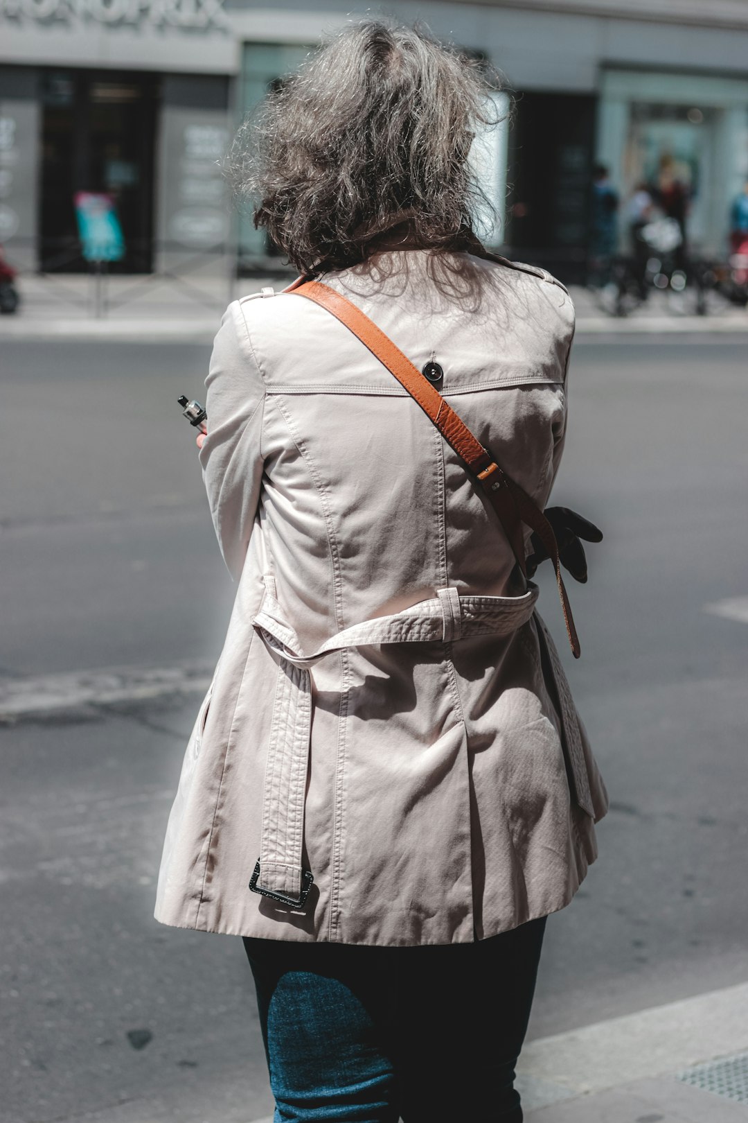 woman in white coat walking on street during daytime