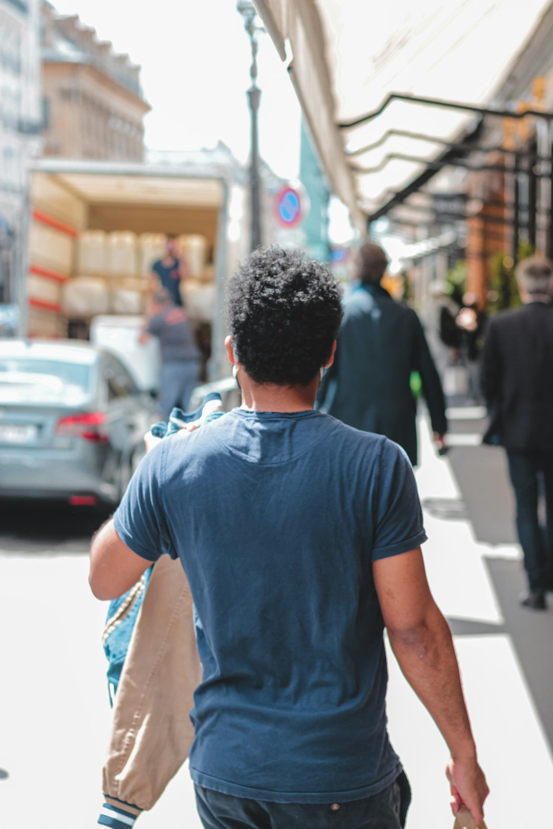 man in black t-shirt walking on street during daytime