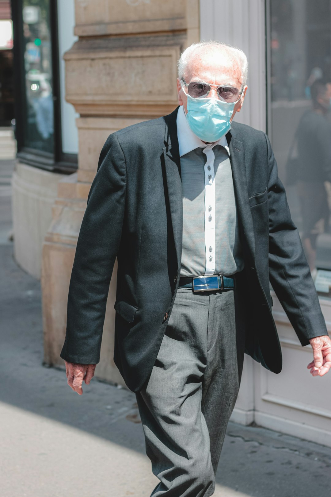 man in black suit jacket and white dress shirt with blue necktie