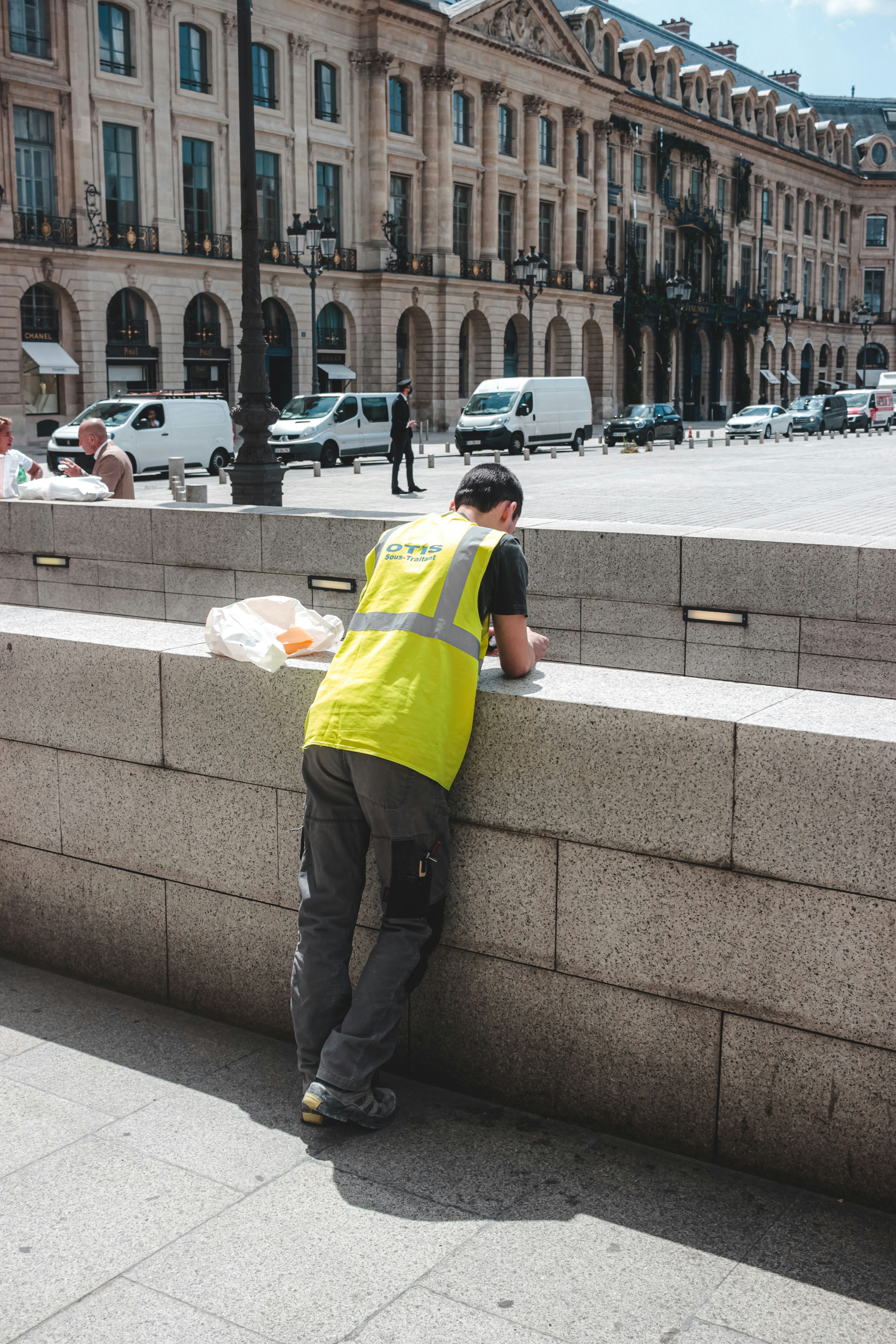 man in yellow shirt and black pants standing on gray concrete pavement during daytime