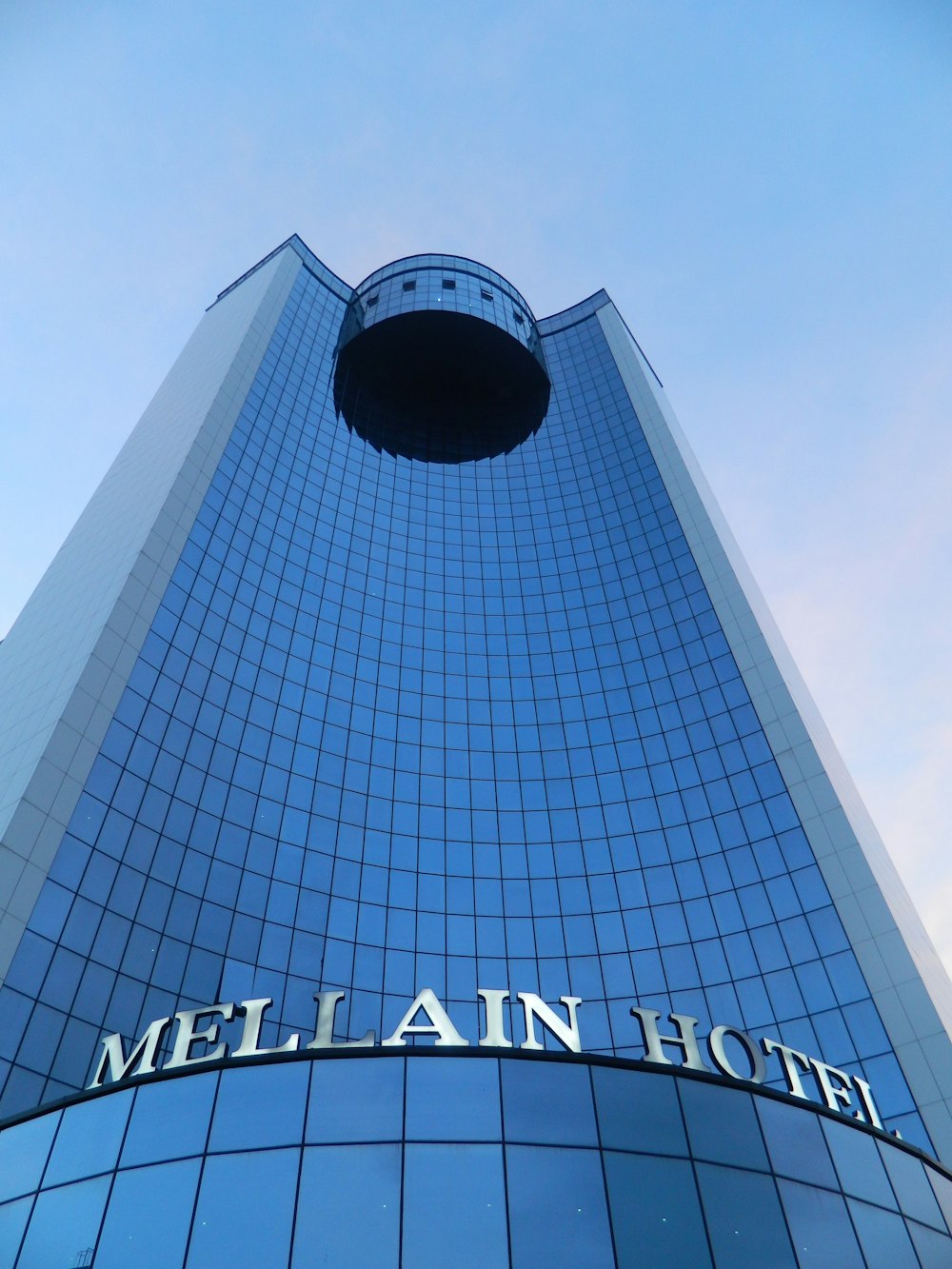 low angle photography of gray and black concrete building under blue sky during daytime