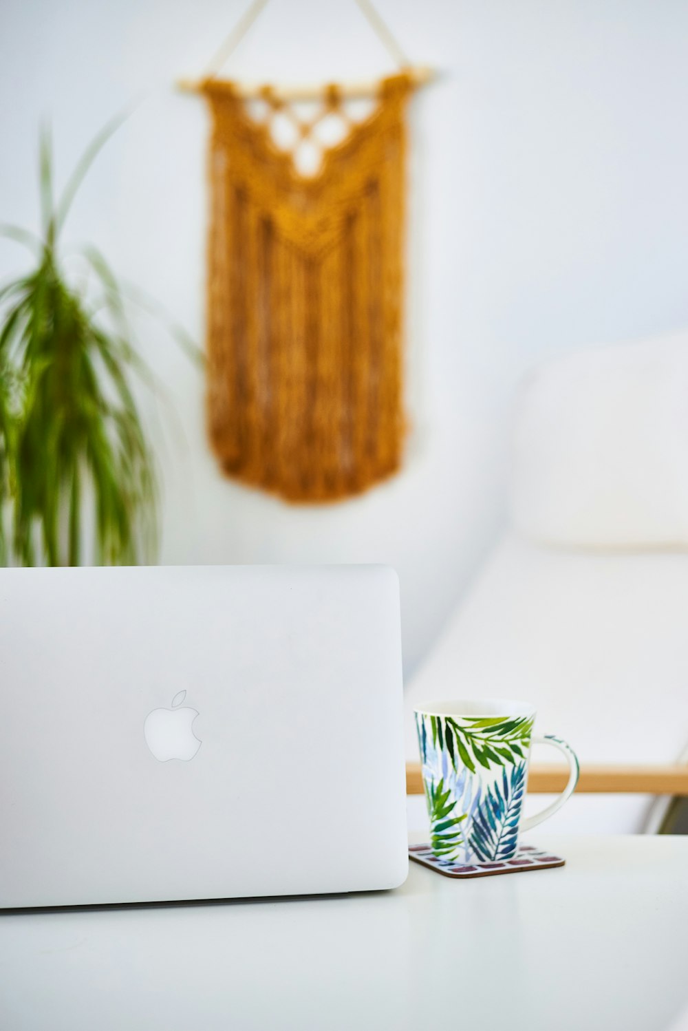 macbook air on white and yellow floral ceramic mug