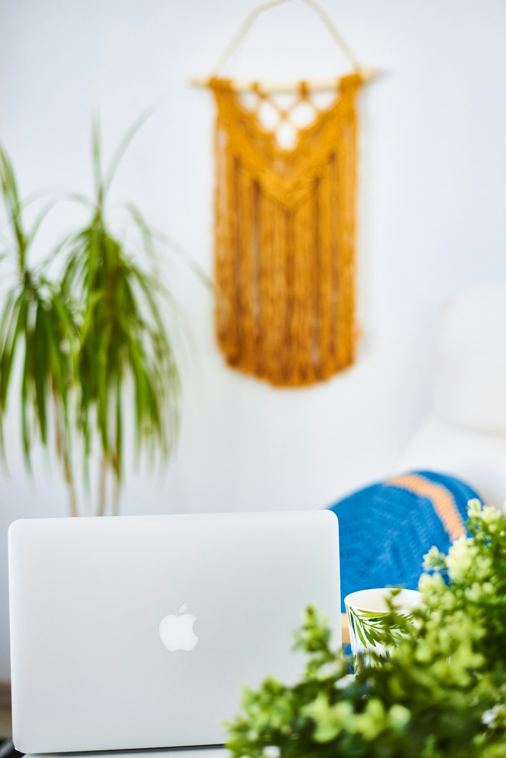 silver macbook on blue and white textile