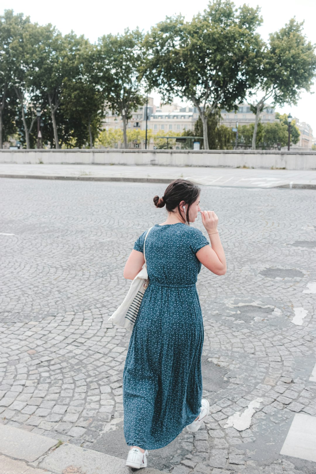 woman in blue dress standing on gray concrete pavement during daytime