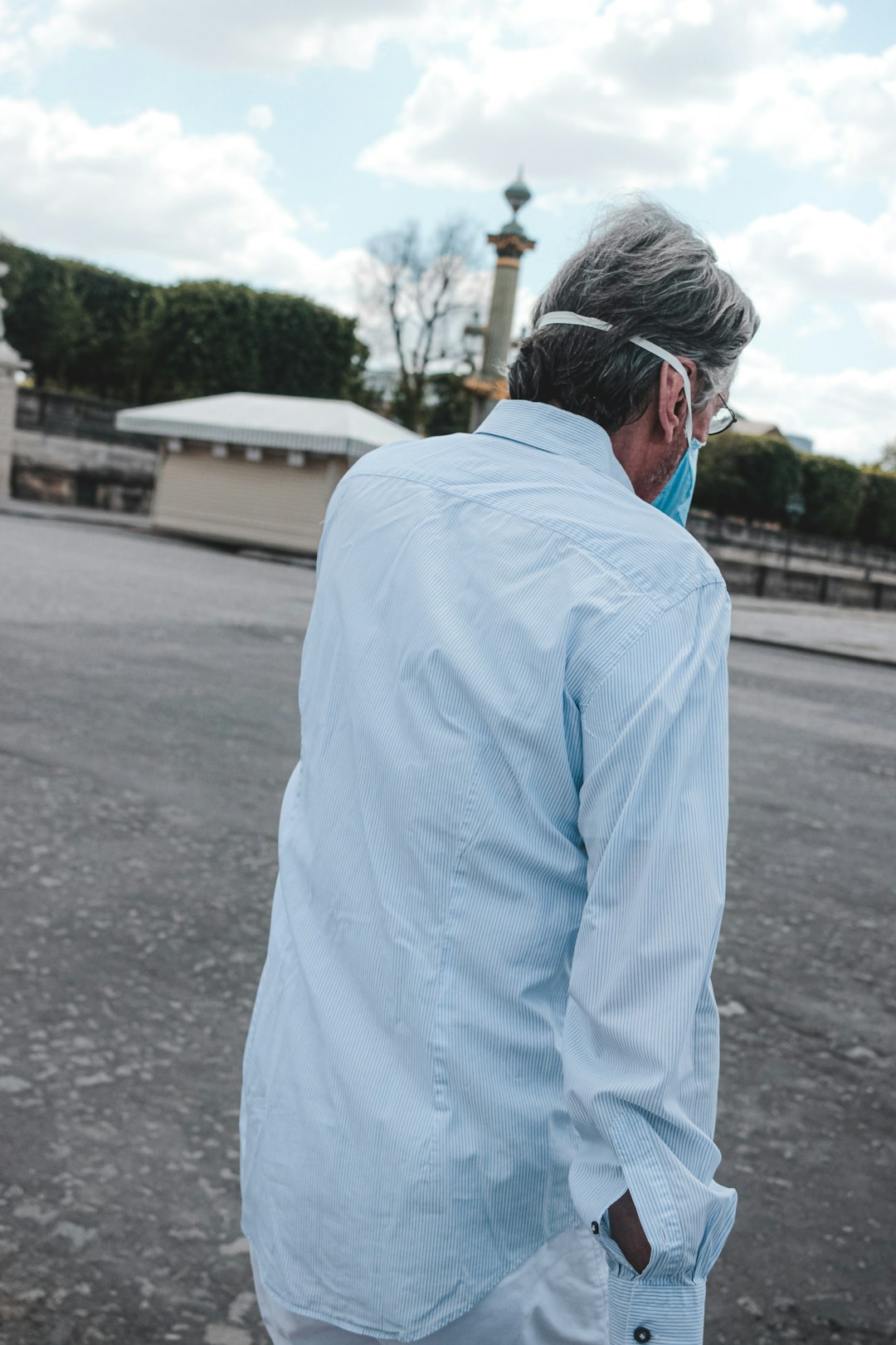 man in white dress shirt wearing blue sunglasses standing on sidewalk during daytime