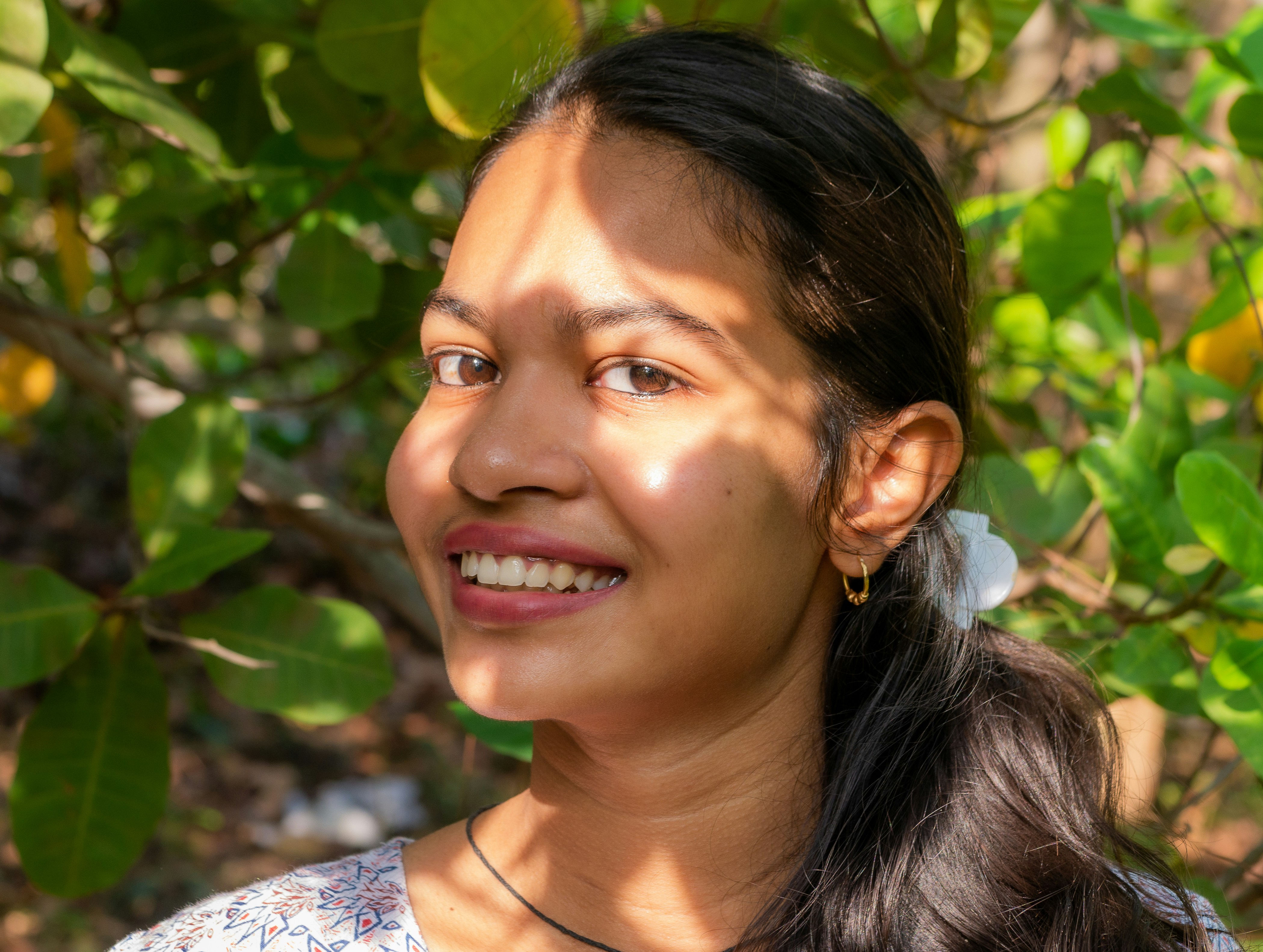 woman in white and blue floral shirt smiling