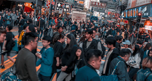 A vibrant snapshot of a bustling city street filled with colorful signs and lively crowds.