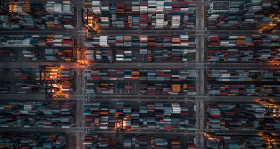 An aerial view of a busy industrial complex with shipping containers and cranes.