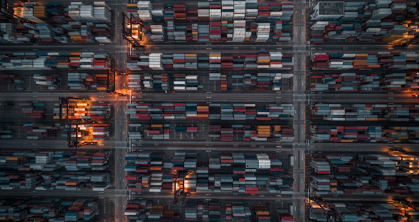 A detailed magnifying glass hovering over shipping containers in a modern Chinese industrial zone.