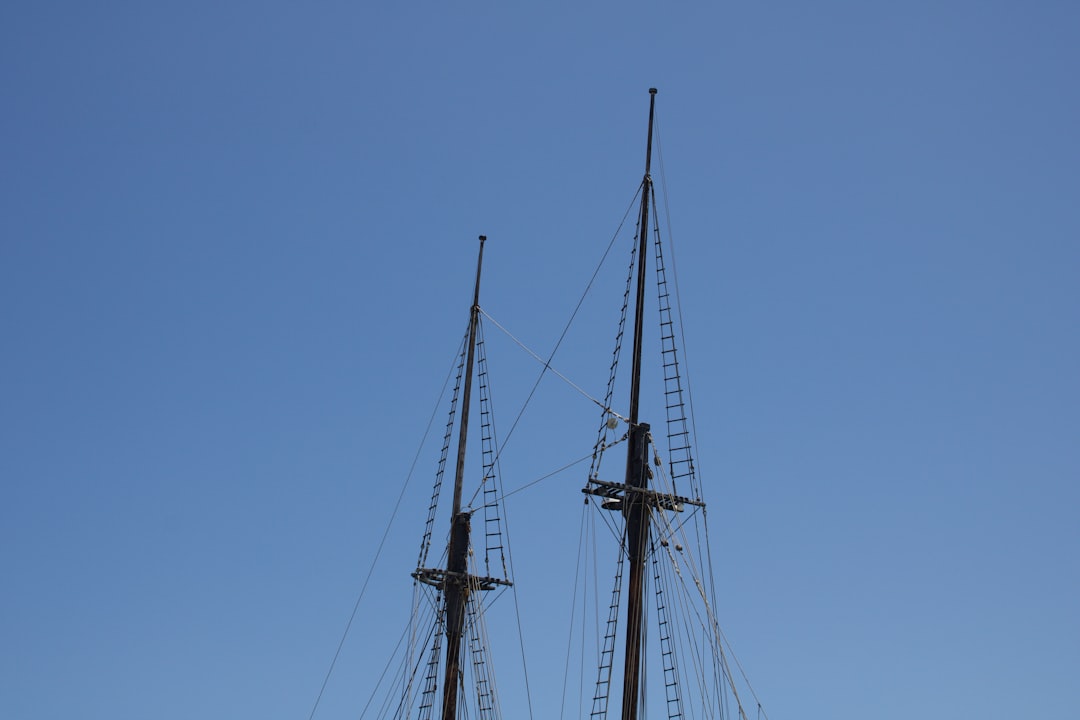 black sail boat on blue sky