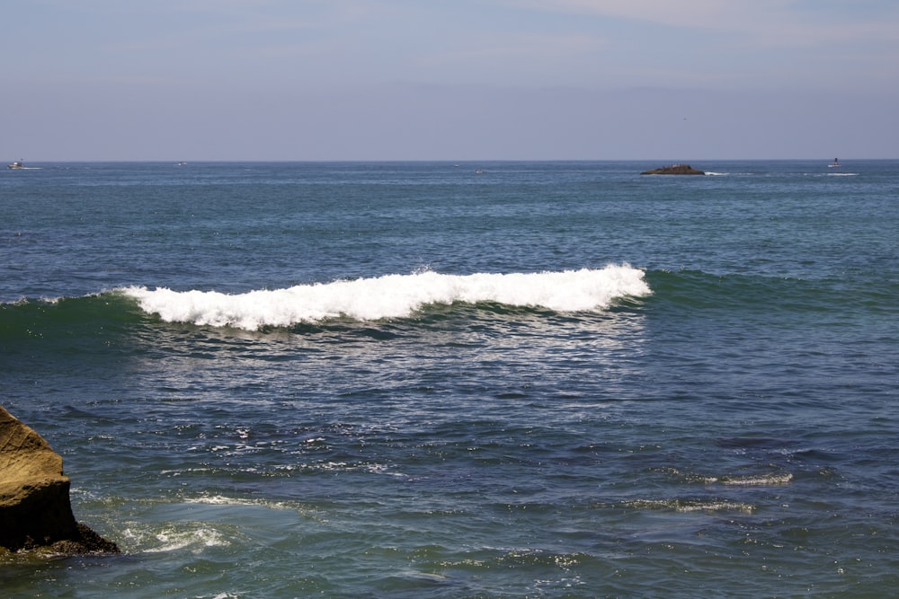 ocean waves crashing on shore during daytime