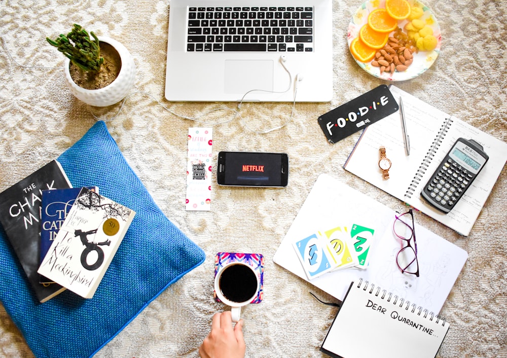 macbook pro beside white ceramic mug on white table