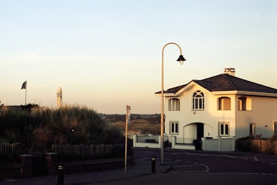 A sunset view of a house with a post sign.
