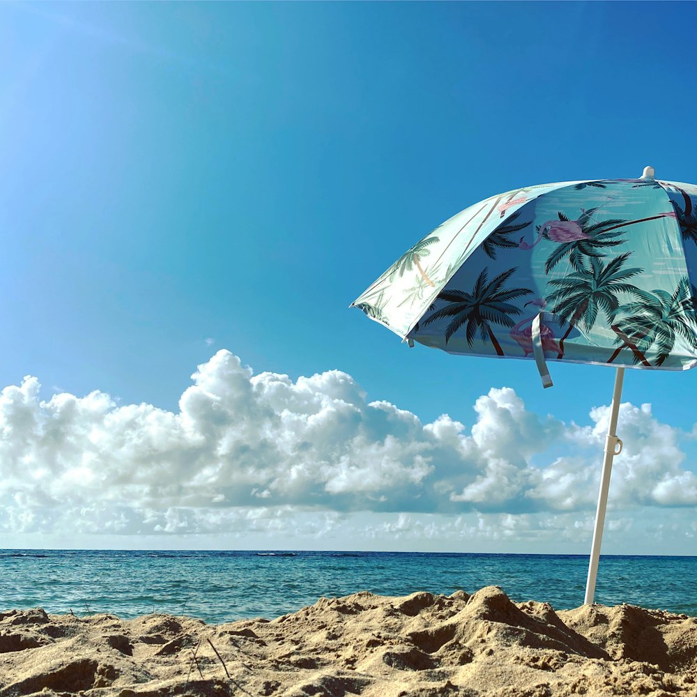 昼間のビーチショアの白と緑の傘