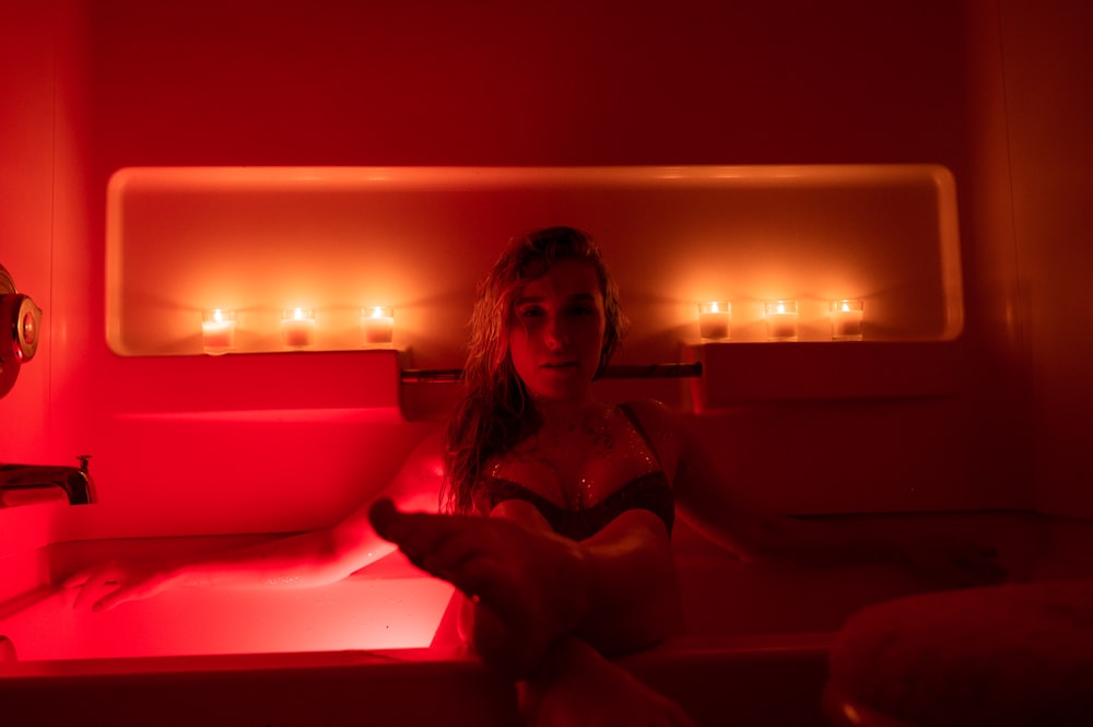 woman in white bathtub with lights turned on during night time