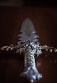 A close-up of a finished sword with ornate tape designs.