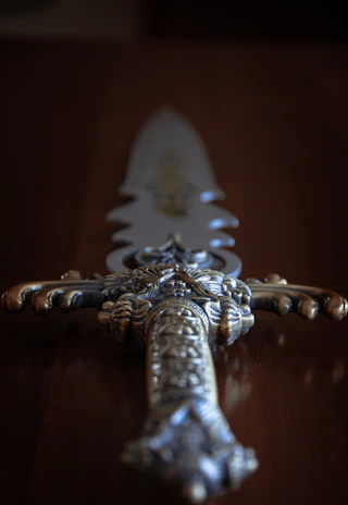 An ornate Indian talwar sword displayed against a rich red velvet background.