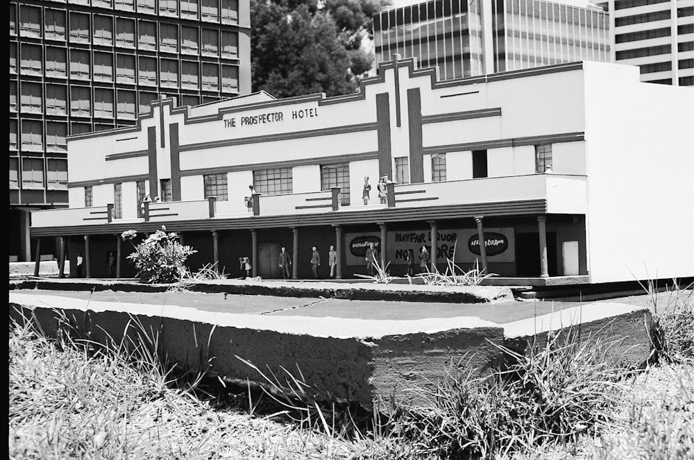 grayscale photo of building near trees