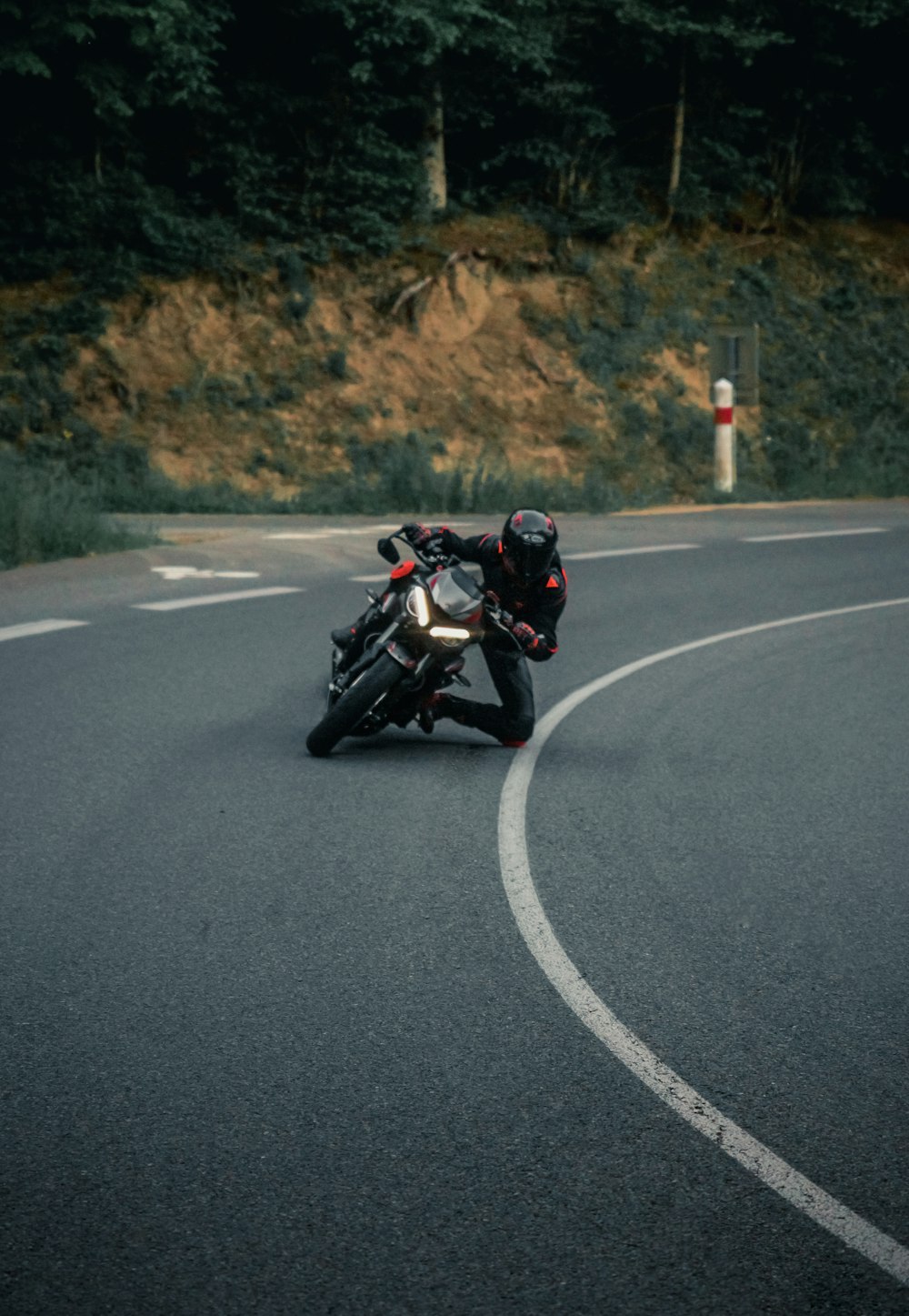 homem na jaqueta preta que monta a motocicleta na estrada durante o dia