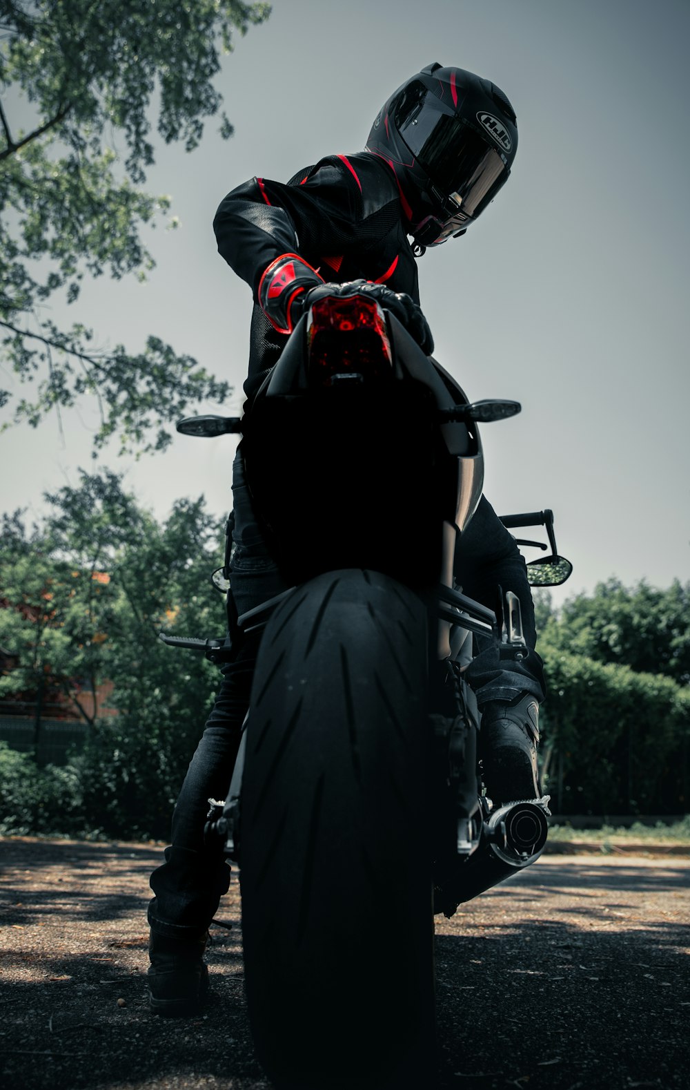 Mann in schwarzer Lederjacke fährt schwarzes Motorrad