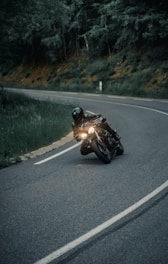 a man riding a motorcycle down a curvy road