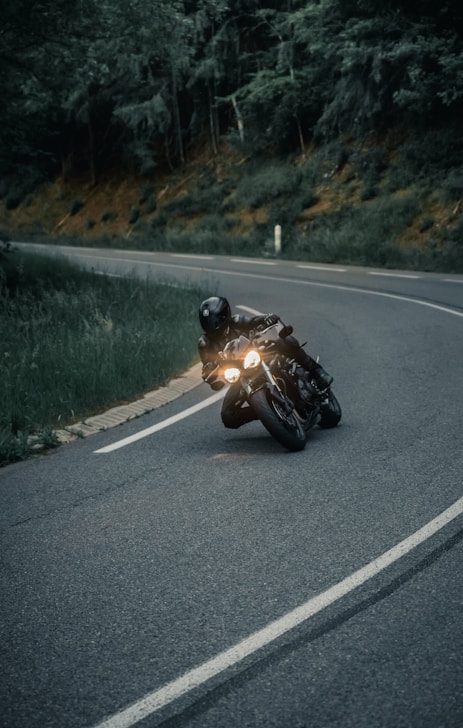 a man riding a motorcycle down a curvy road
