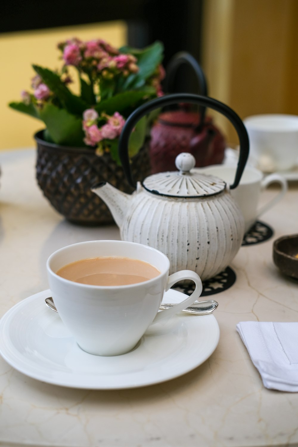 white ceramic teacup on white ceramic saucer