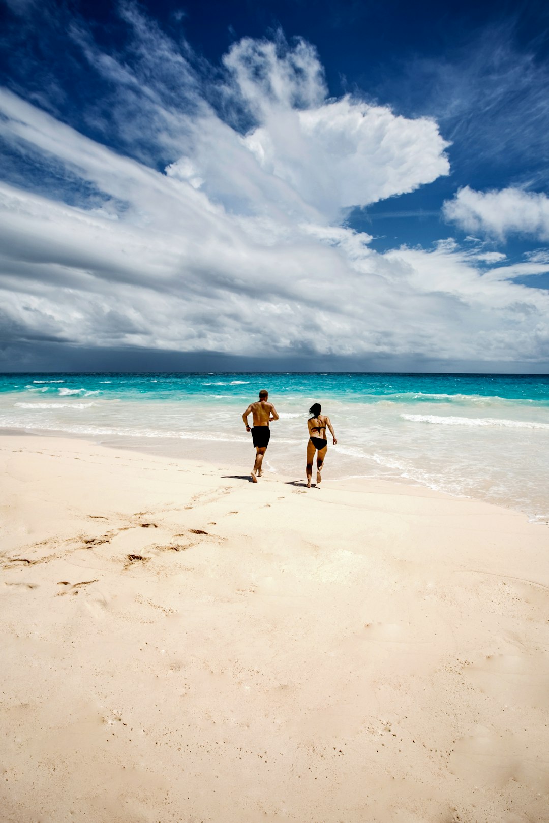 2 women walking on beach during daytime