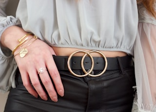 person wearing gray shirt and black leather belt