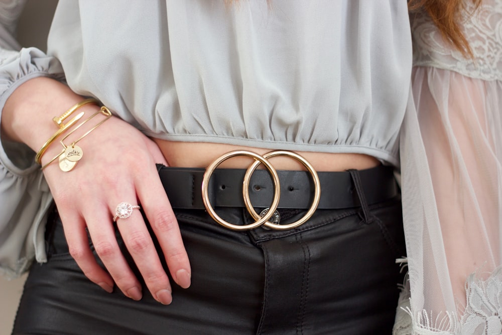 person wearing gray shirt and black leather belt